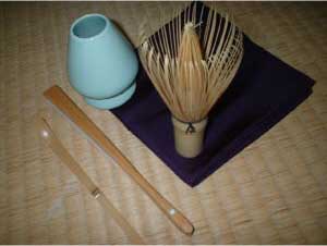 Purple fukusa silk cloth with Japanese tea ceremony implements including whisk and tea scoop