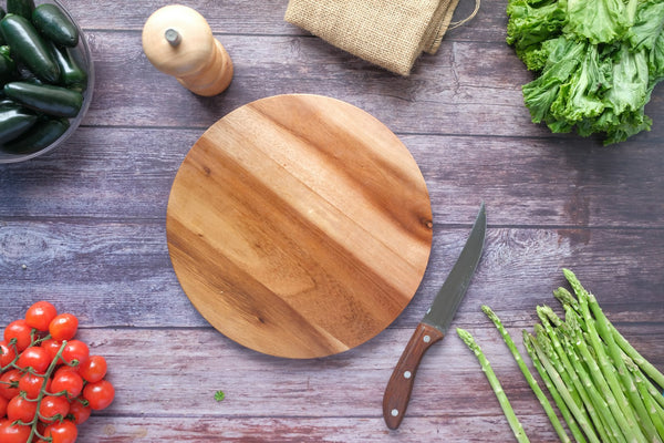 Clean wooden cutting board beside fresh green vegetables