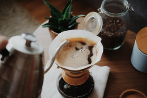 Pour-over coffee being brewed into a glass server