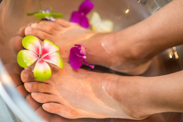 Bare feet resting with flowers nearby
