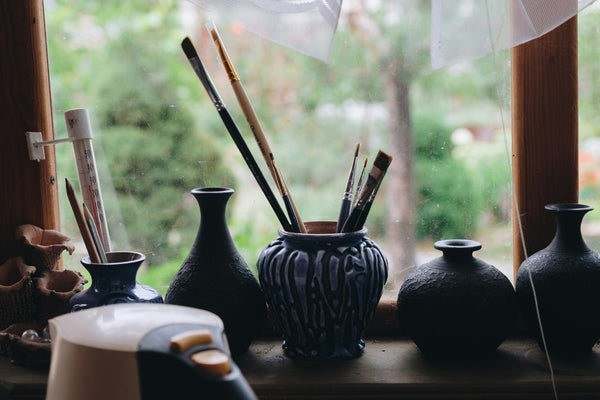 Ceramic vessel being used to hold brushes, illustrating an object taking on a new function