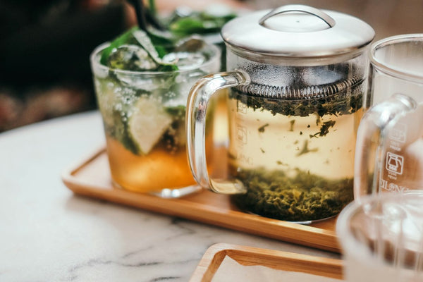 Clear glass of chilled green tea on a tray