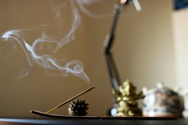 Incense burning with a thin trail of smoke