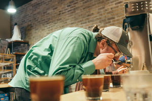 Person tasting a cup of black coffee
