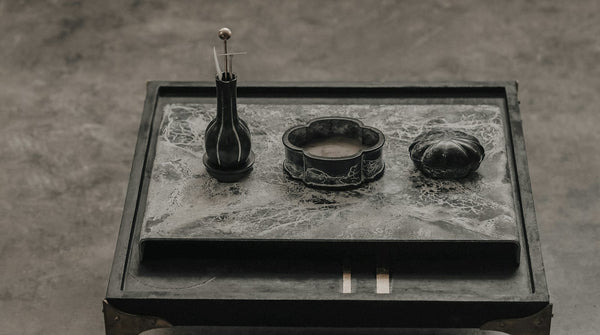 Japanese tea utensils arranged neatly on a dark tray