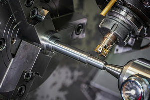 A metal rod being machined with a precision cutting tool