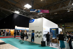 Visitors gathered around booths in a trade exhibition hall