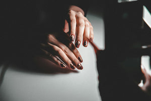 Hands with neatly groomed natural nails resting on a piano
