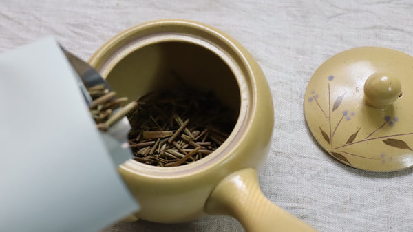 Teapot beside a cup of roasted tea