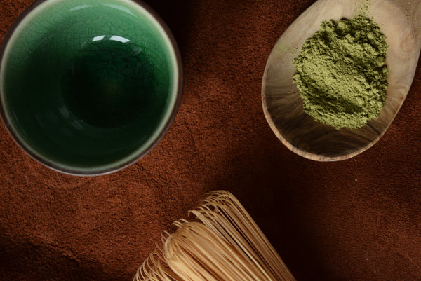 Fine green matcha powder with a bamboo whisk and tea bowl