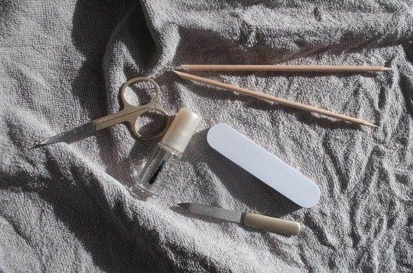 Metal manicure tools laid out on a white towel