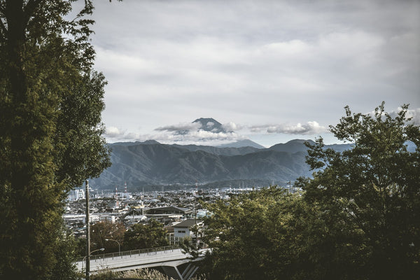 Distant mountain emerging through clouds, illustrating the landscape idea behind the Toyama ash-form name in Japanese tea