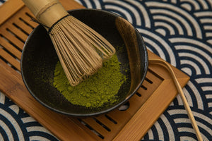 Matcha powder with bamboo whisk and scoop used as a contemporary chashaku reference
