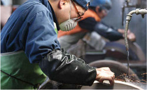 Knife maker grinding blades in a Japanese workshop
