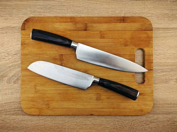 Kitchen knives resting on a wooden cutting board surface