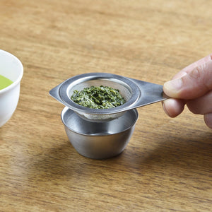 KOGU tea strainer resting with its stainless steel saucer